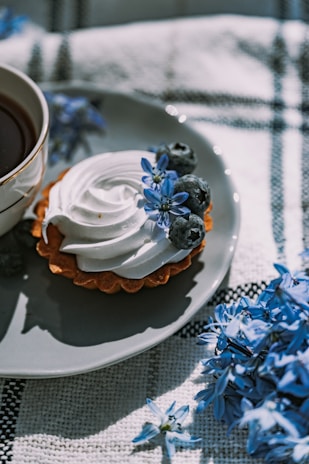 Close-up of a delicate handmade tart with a golden crust, filled with fresh berries and cream, perfect morning treat inside the cozy café corner.