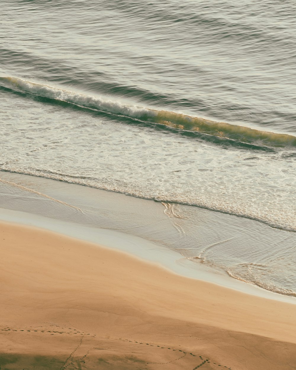 a man riding a surfboard on top of a sandy beach