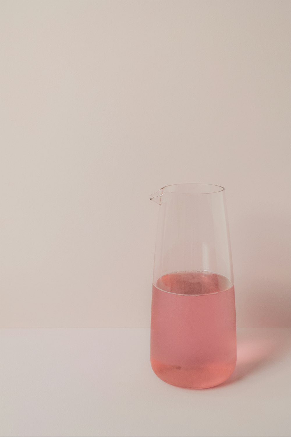 Un liquide rose est dans un vase en verre