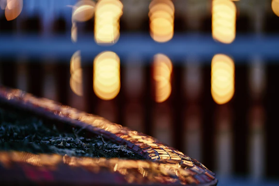 A close-up of a vibrant mosaic tile artwork illuminated by soft natural light.
