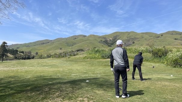 Two golfers discussing strategy while standing on the green.