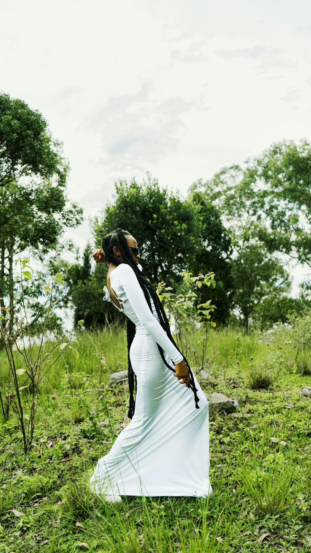 a woman in a white dress standing in a field