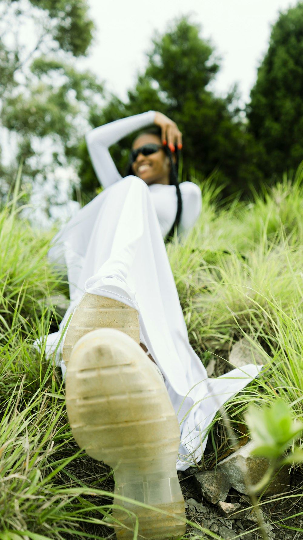 a woman in a white dress sitting in the grass