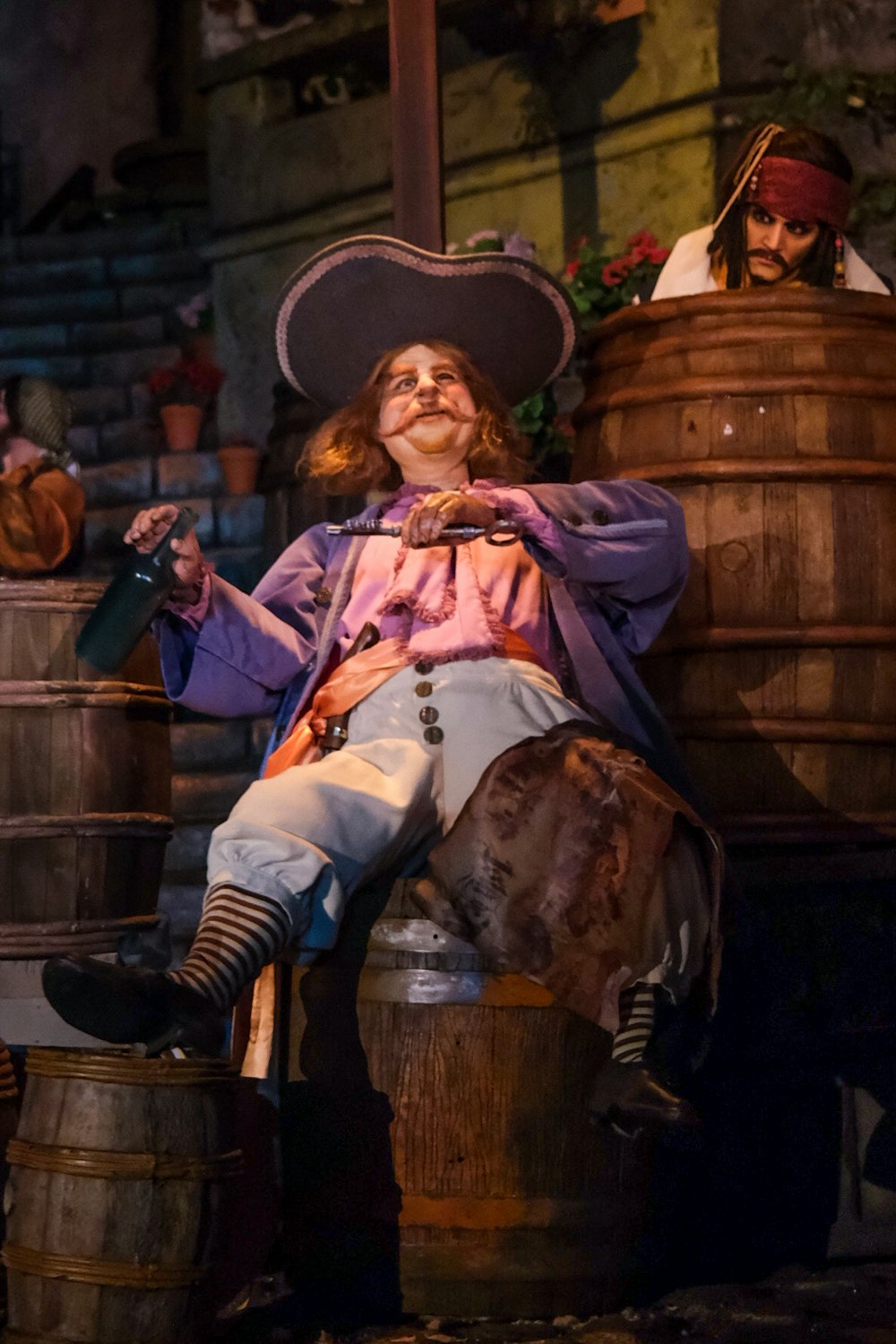 a man in a pirate costume sitting on a barrel