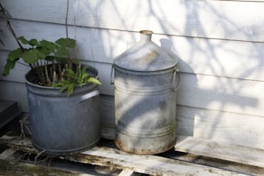 a bucket and a potted plant on a porch