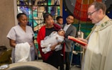 A serene baptism ceremony with a child surrounded by family and church members.