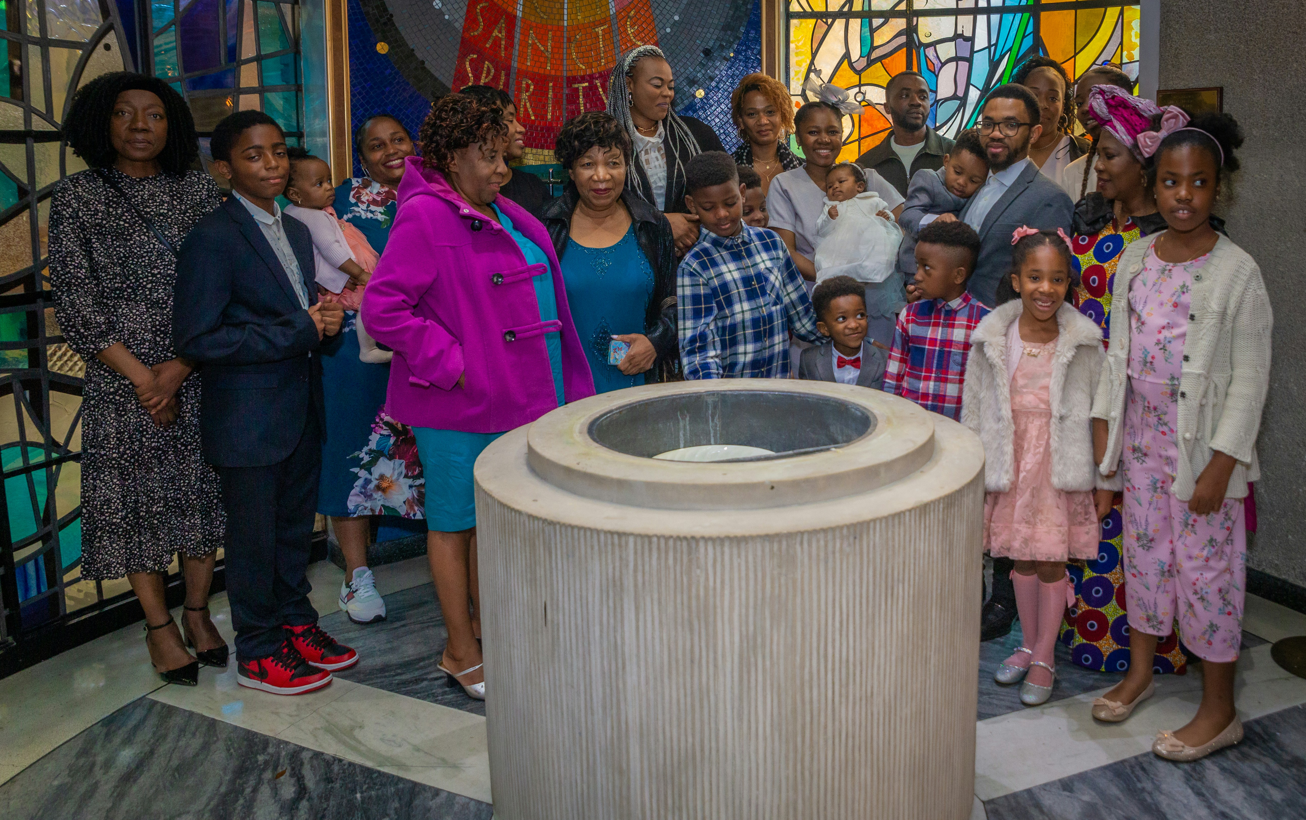 a group of people standing in front of a stained glass window