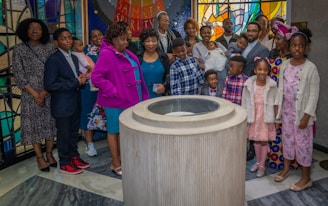 a group of people standing in front of a stained glass window