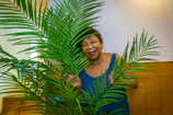 Photo of Dra. Eliana warmly smiling in her consultation room filled with plants.