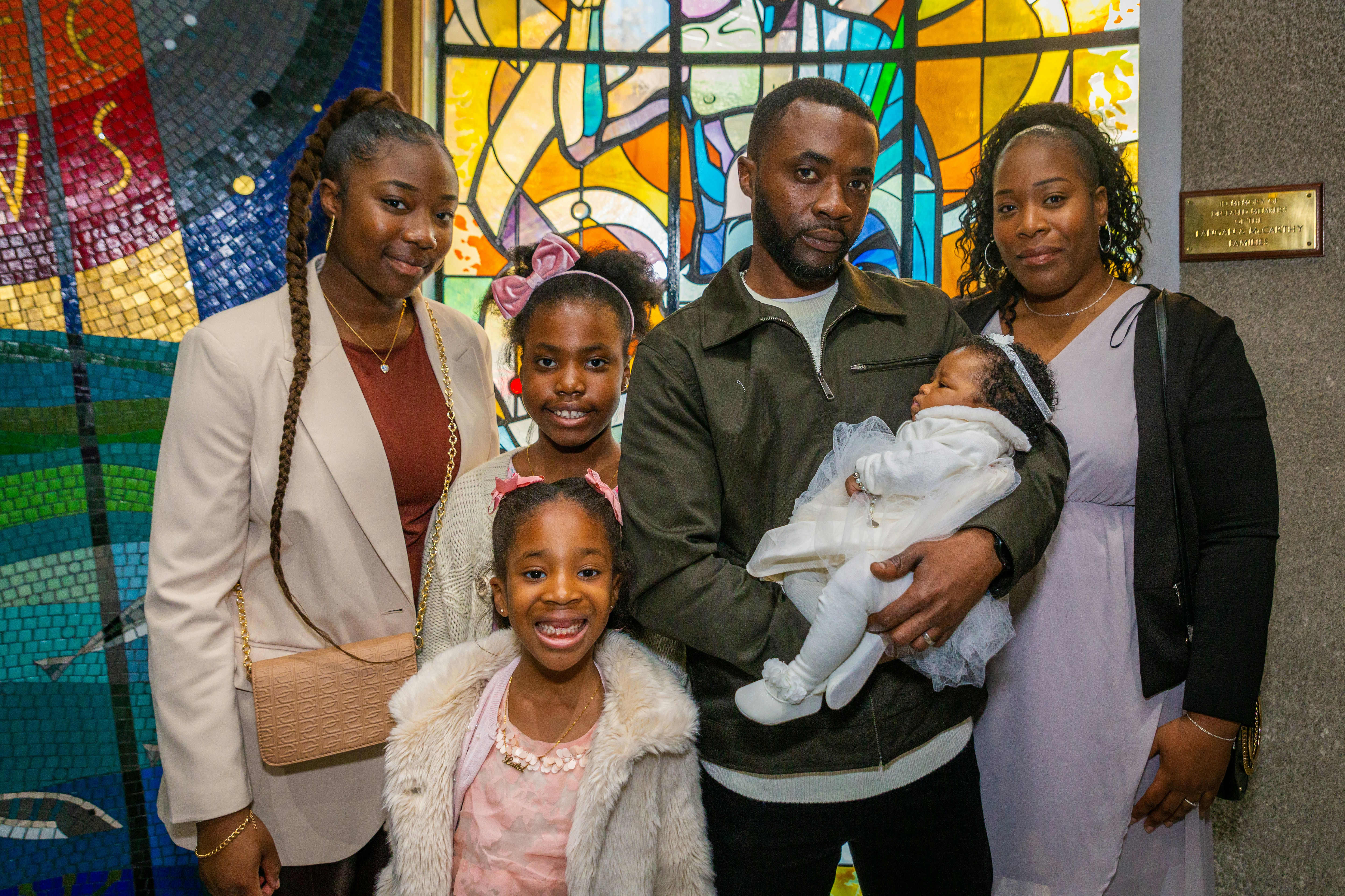 a family poses in front of a stained glass window