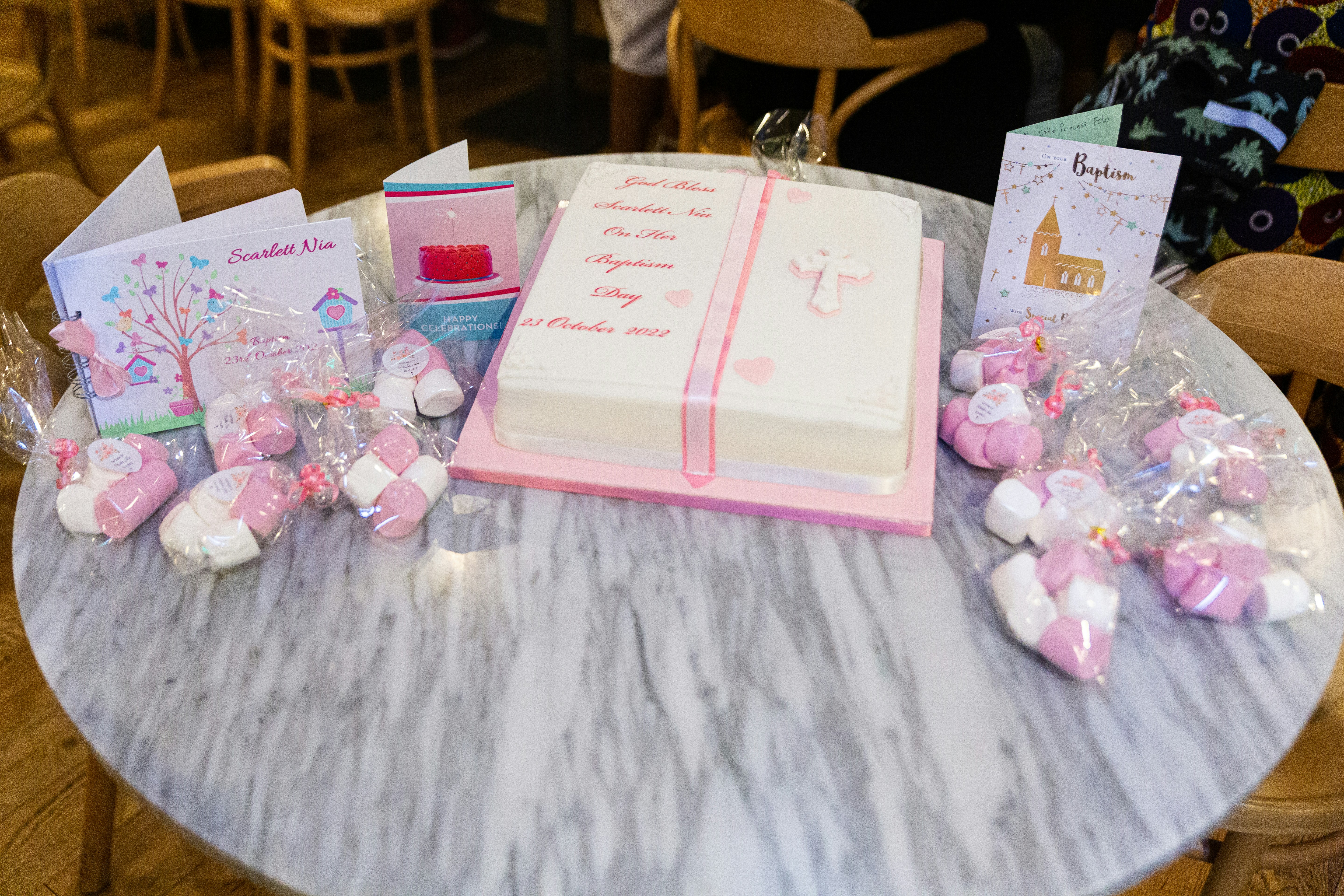 a table topped with a cake covered in pink and white frosting