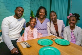 a group of people sitting around a wooden table