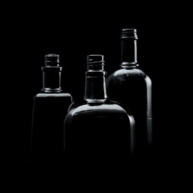 three empty bottles are shown in black and white