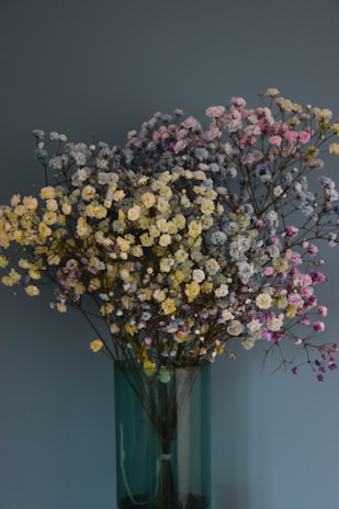 An elegant bouquet of wildflowers in a rustic vase, painted with fine detail.