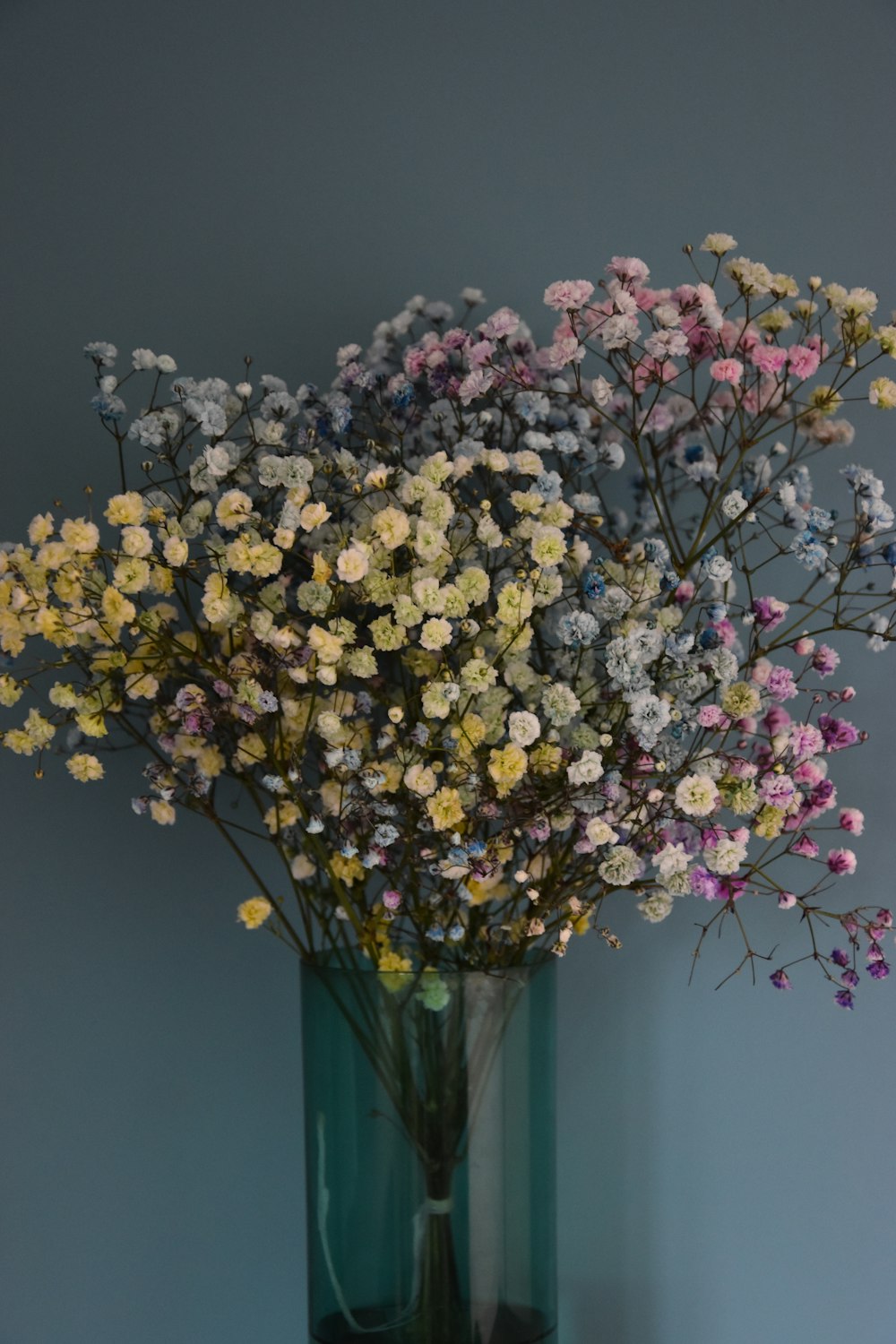 a vase filled with lots of different colored flowers