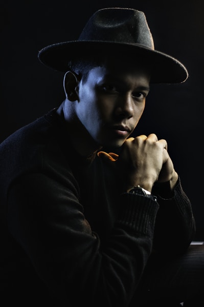 a man with a hat and a watch on his wrist