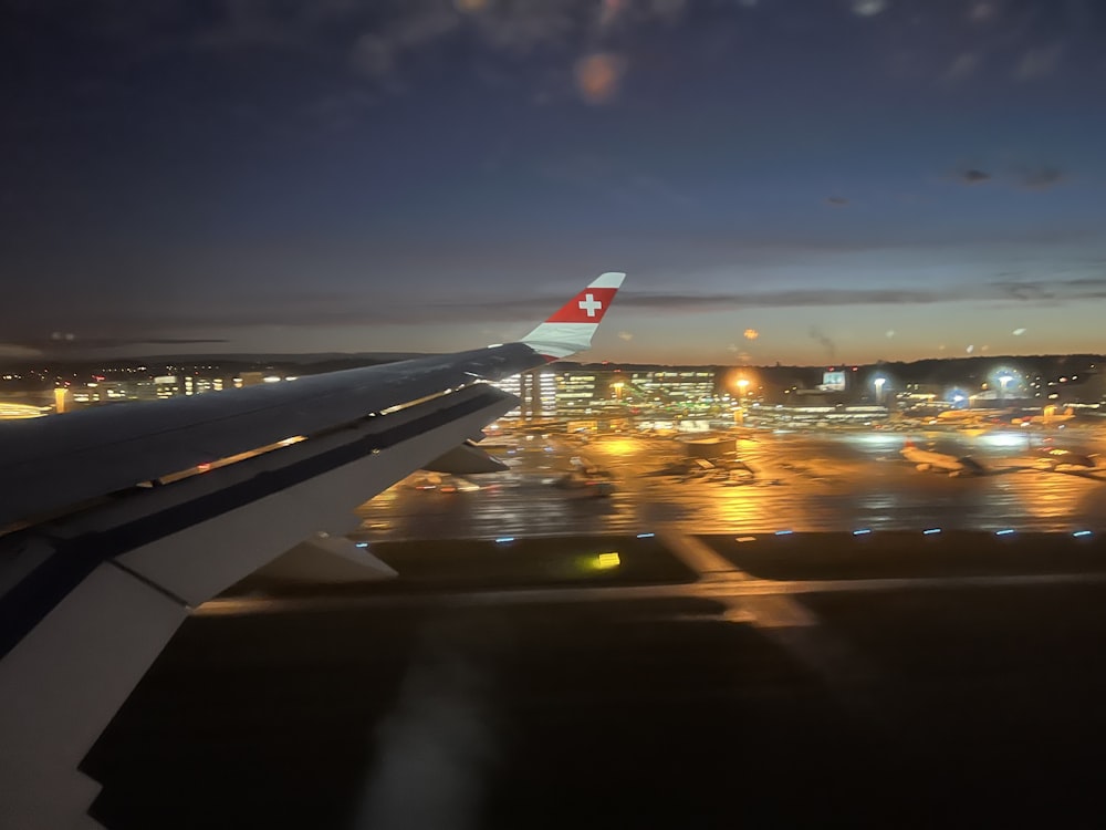 uma vista de um aeroporto à noite a partir de uma janela de avião