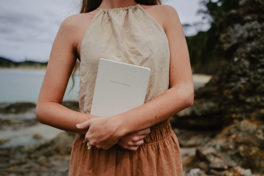 Una mujer sosteniendo un libro en sus manos