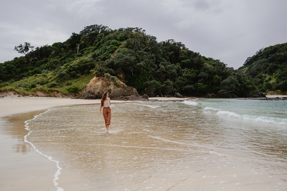 Una donna in piedi nel surf su una spiaggia