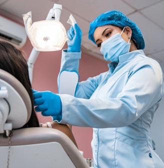 a woman getting her teeth brushed by a dentist