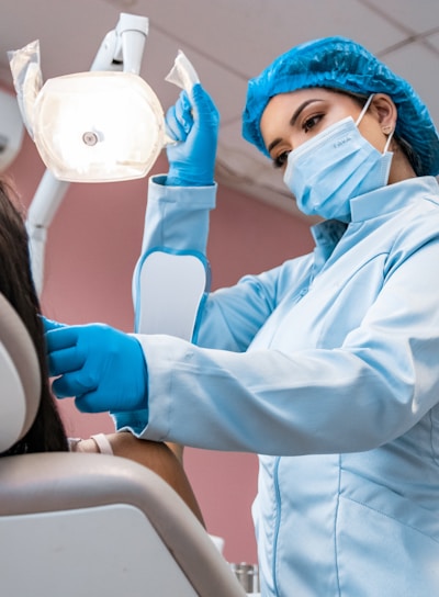 a woman getting her teeth brushed by a dentist