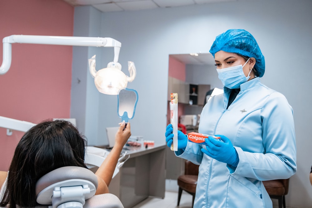 a woman in a dentist's office holding a toothbrush