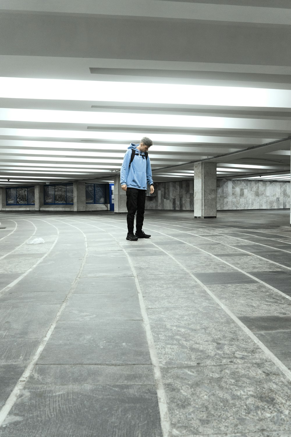 a man standing in a parking garage with a backpack on his back