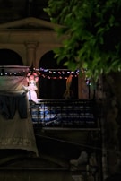 String lights draped across a balcony railing, casting a gentle, inviting glow.
