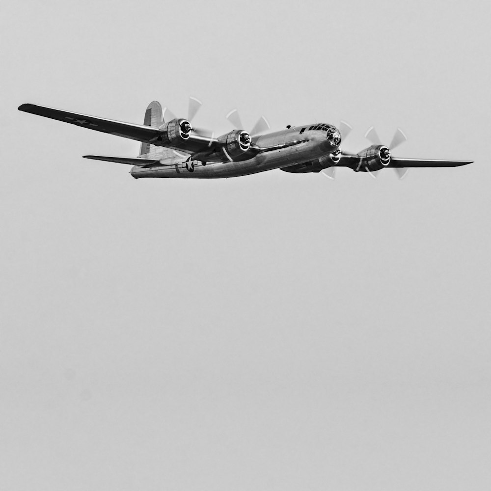 Une photo en noir et blanc d’un avion volant dans le ciel