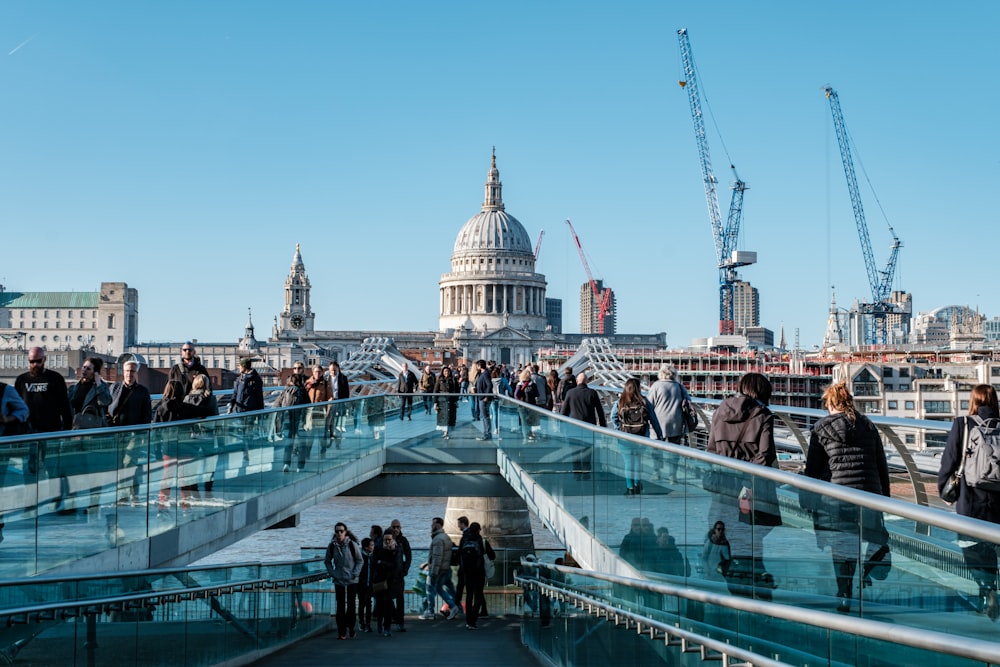 a group of people walking across a bridge