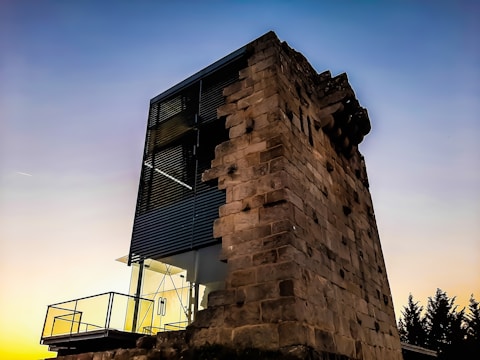 Sunset over a restored historic building blending old stone with modern glass.