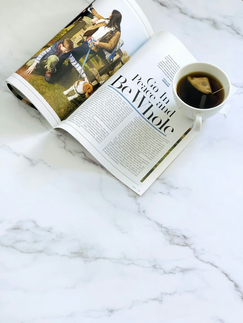 uma xícara de café sentada em cima de uma revista