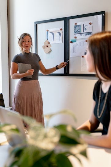 A professional woman confidently presenting sales growth charts in a modern office.