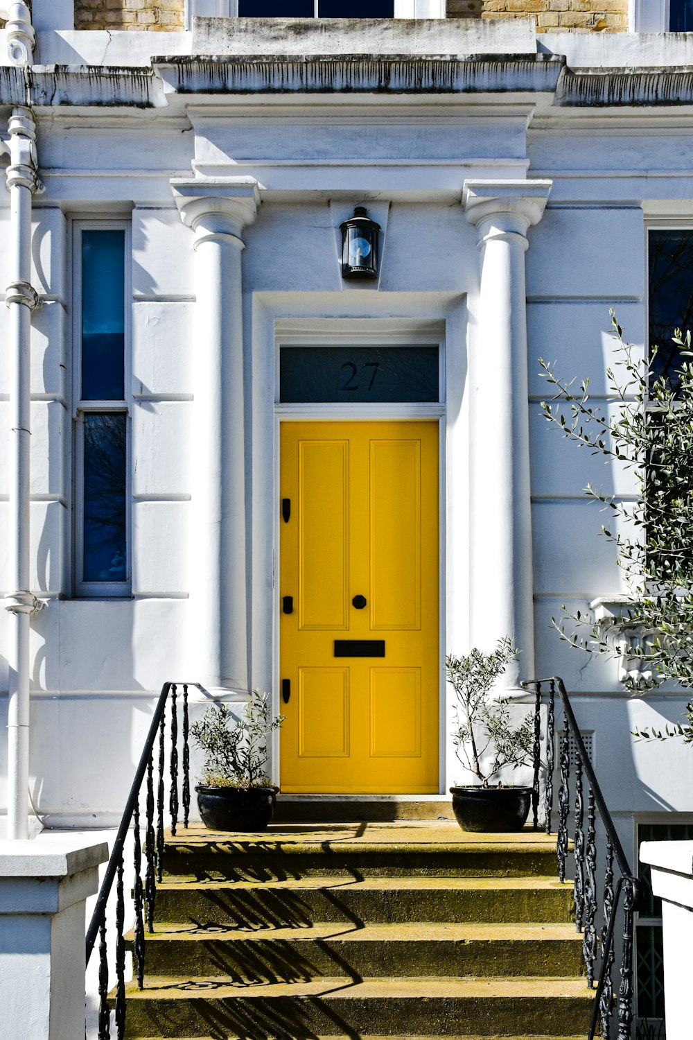 a yellow door is on a white building