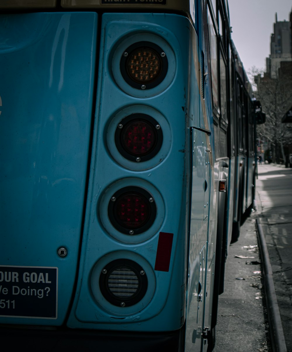 a blue bus stopped at a bus stop