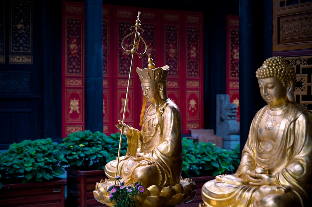 a golden statue of buddha holding a balance scale