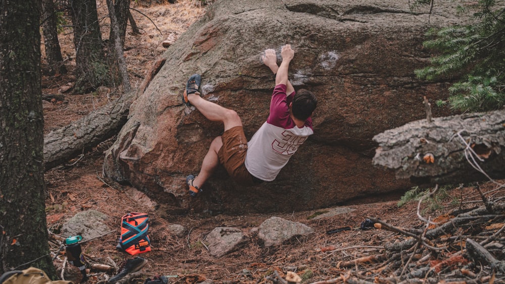 a man climbing up the side of a large rock