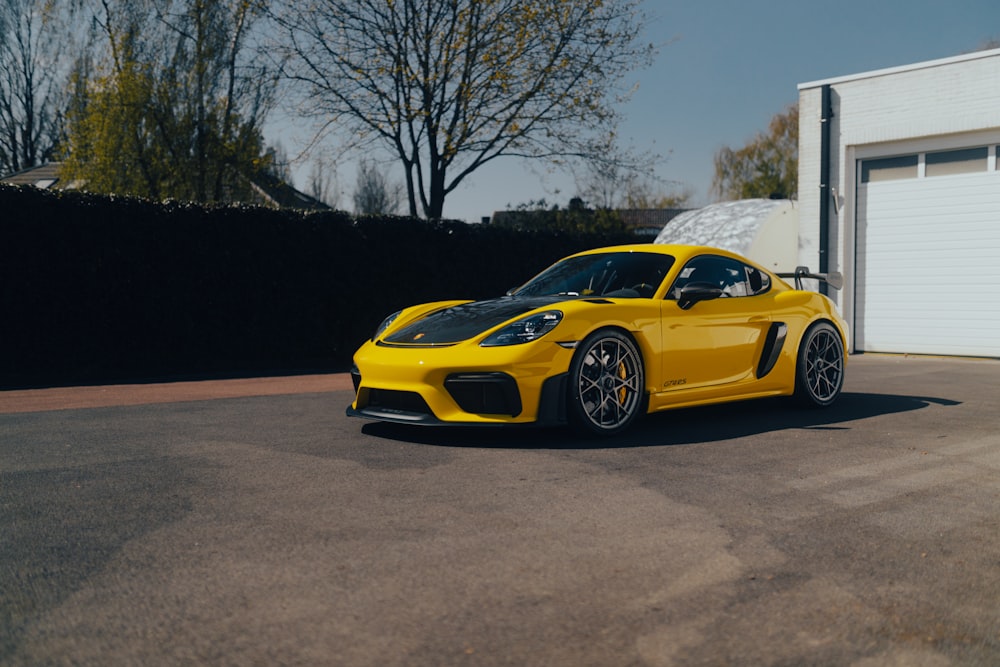a yellow sports car parked in front of a garage