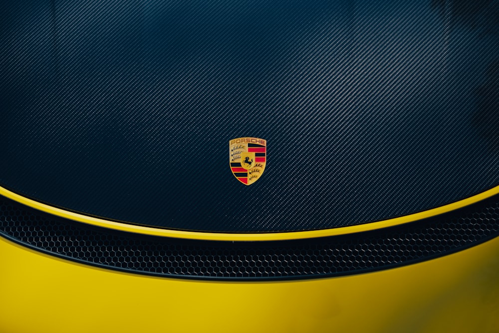 the emblem on the front of a yellow sports car