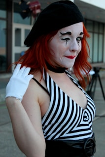 Close-up shot of a mime artist with white face paint and detailed gestures against a black background
