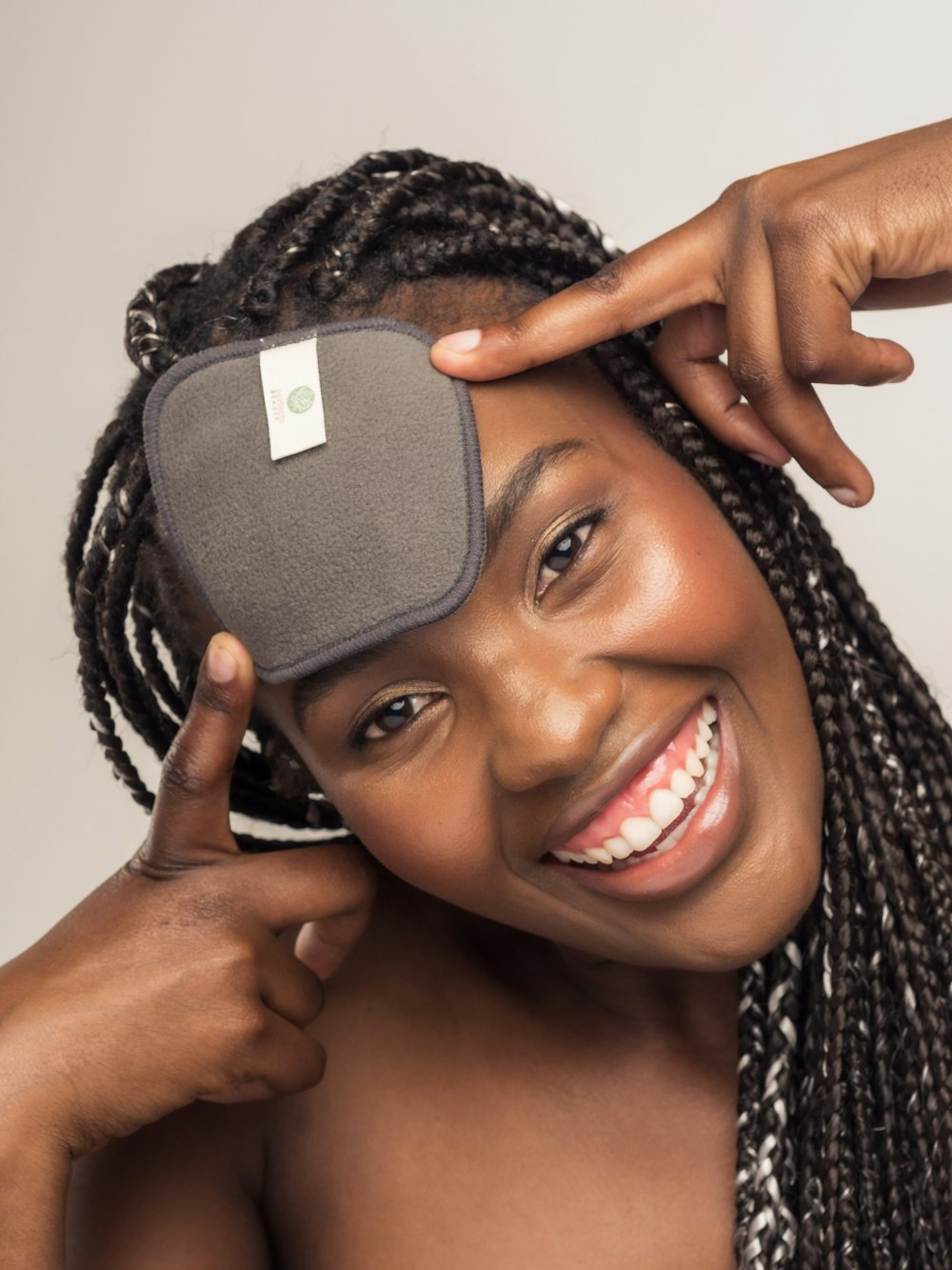 a woman is smiling while holding a cell phone up to her face