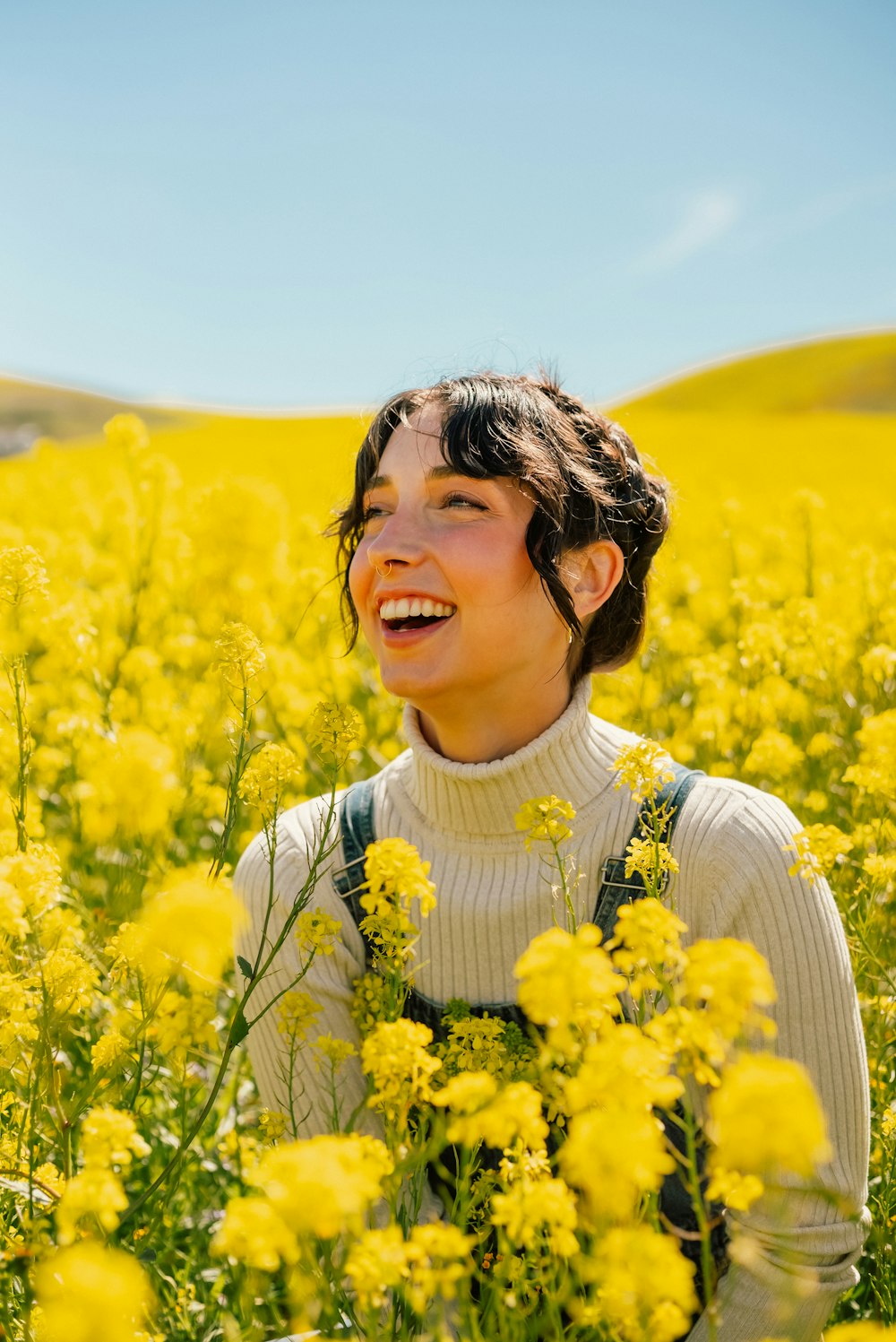 a woman standing in a field of yellow flowers