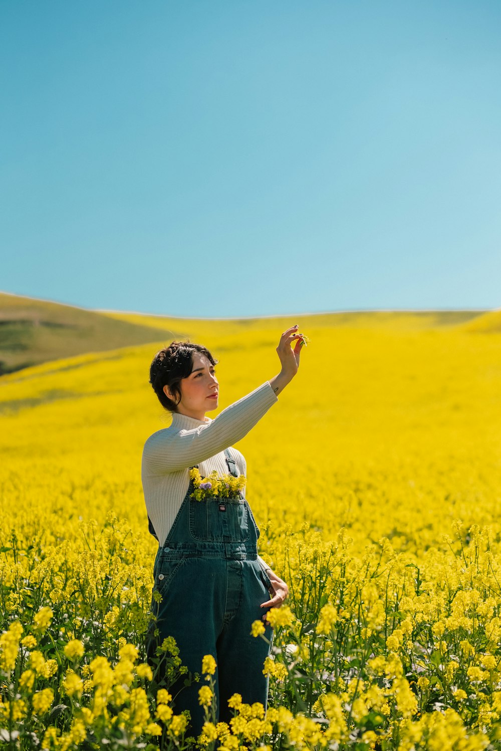 a woman standing in a field of yellow flowers