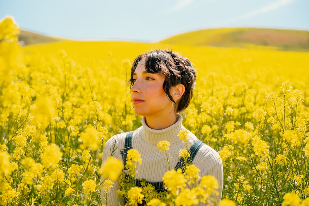 a woman standing in a field of yellow flowers