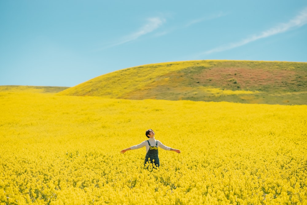 a person standing in a field of yellow flowers