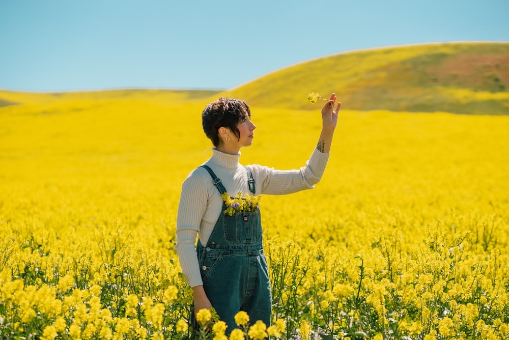 a woman standing in a field of yellow flowers