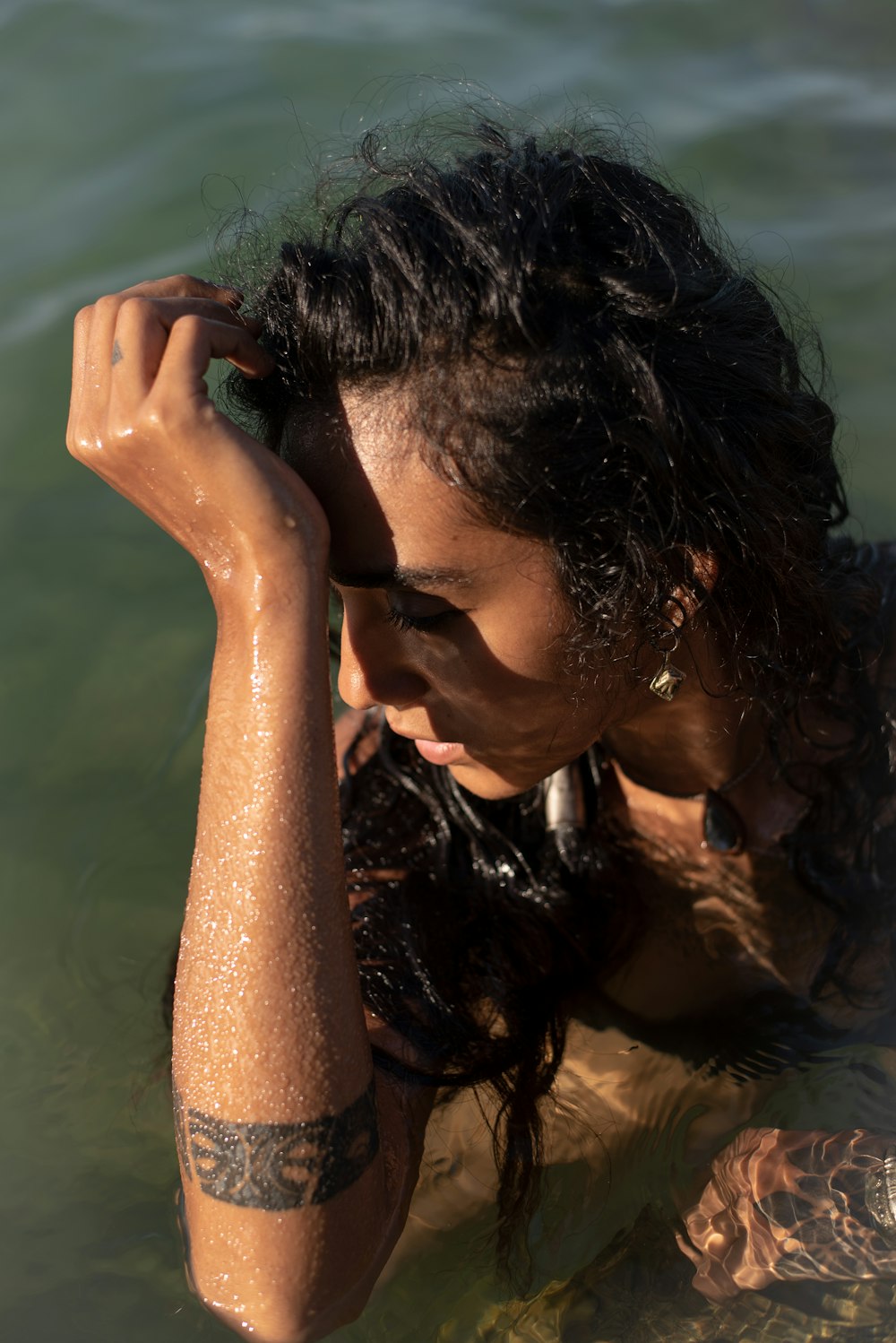 a woman in a body of water with her arm around her head