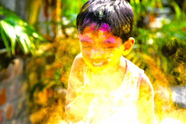 A child laughing while playing with colorful confetti during a party