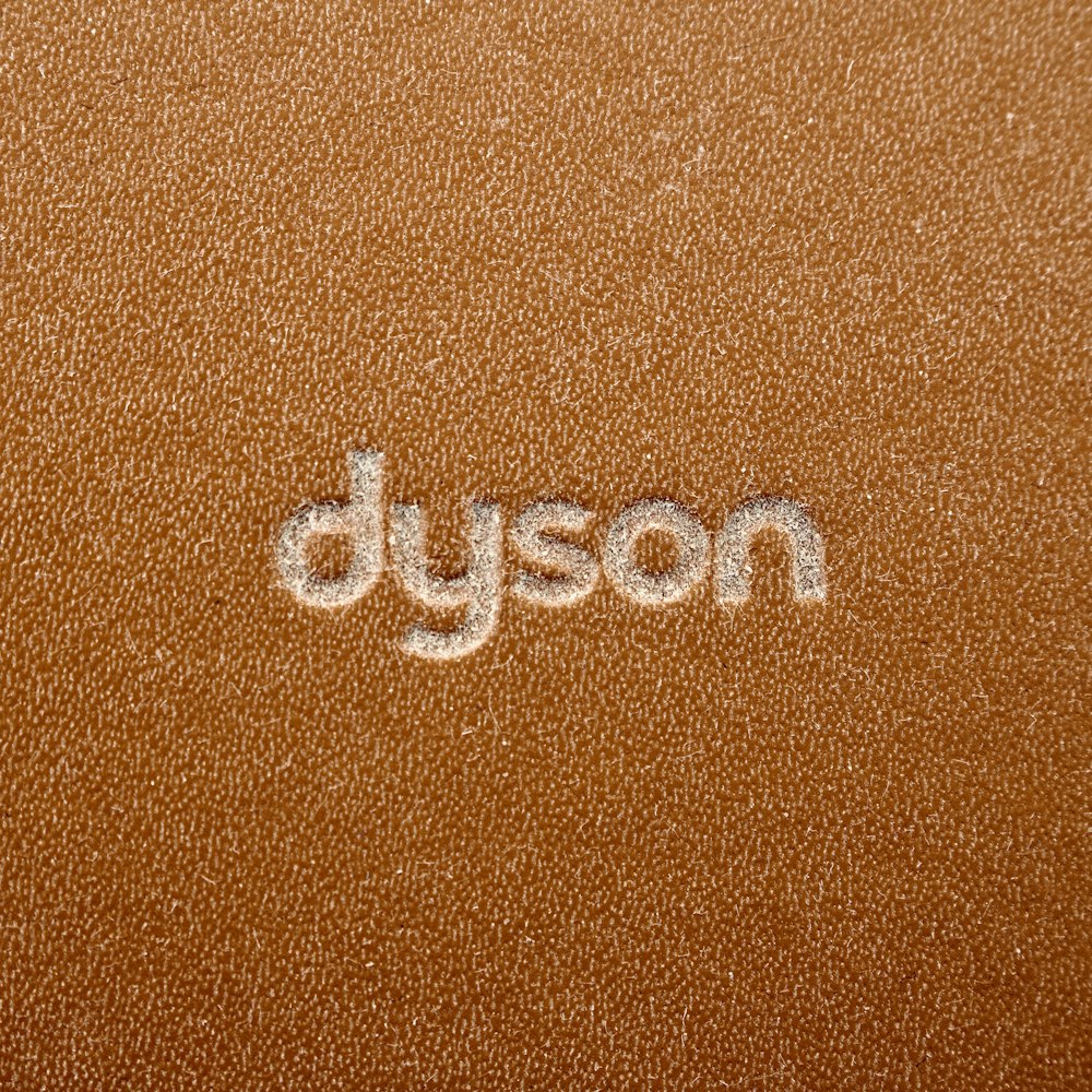 un gros plan du mot Dyson écrit sur une surface en cuir