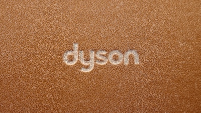 the word dyson written on a brown leather surface